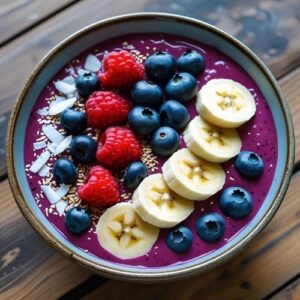 Smoothie Bowl mit Beeren, Bananenscheiben und Kokosraspeln in einer Schale